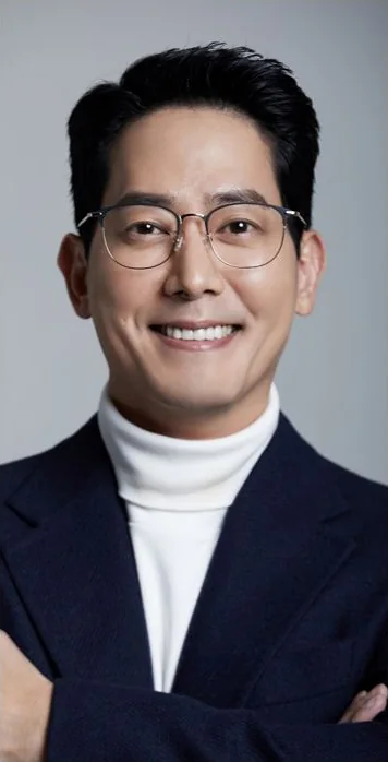 배우 김선혁 프로필 사진 — 안경·네이비 재킷·흰 터틀넥, 웃음